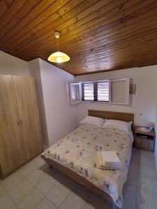 - une chambre avec un lit et un plafond en bois dans l'établissement Holiday house "Uvala Jaz - Telašćica", à Sali