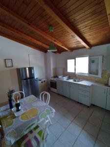 une cuisine avec une table et une cuisine avec une table et des chaises dans l'établissement Holiday house "Uvala Jaz - Telašćica", à Sali