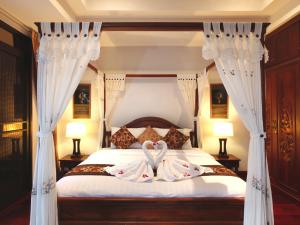 a bedroom with a bed with two swans towels on it at Kata Sea View Villas in Kata Beach