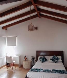 1 dormitorio con cama y escritorio. en Quinta Santa Paula, en Anapoima