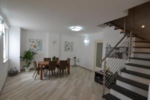 ein Esszimmer und ein Wohnzimmer mit einem Tisch und einer Treppe in der Unterkunft B&B Canavaccio in Urbino