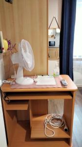 Elle comprend un bureau avec un ventilateur. dans l'établissement Beaublache Résidence studios meublés, à Grenoble