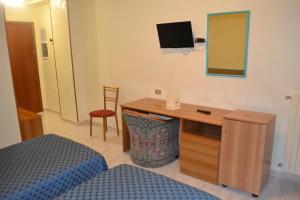 a bedroom with a bed and a desk with a mirror at La Villa dei Gourmets - Struttura Sanificata in Foggia