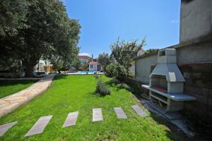 a garden with a bench in the grass at Apartment 877-1 in Bibinje +36 photos