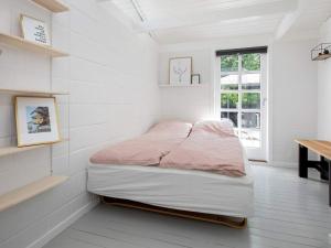 een bed in een kamer met witte muren en een raam bij Holiday home Strøby VIII in Strøby