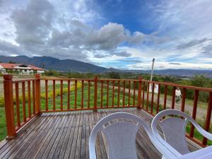 una terraza con 2 sillas y vistas a las montañas en GLAMPING VILLA PALVA en VILLA DE LEYVA en Villa de Leyva