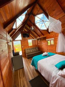 sypialnia z łóżkiem i kanapą w pokoju w obiekcie GLAMPING VILLA PALVA en VILLA DE LEYVA w mieście Villa de Leyva