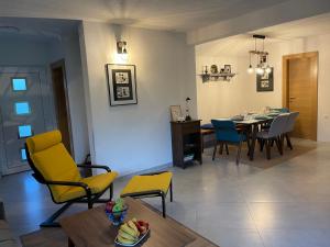 a living room with a table and yellow chairs at Una Verde in Bihać