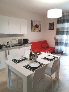 a kitchen with a white table and a red couch at Suite Maria in Agliana