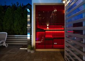 a room with red furniture on a patio at night at Orbisa Bis w cenie Basen podgrzewany Sauna Jacuzzi Rowery Parking Klimatyzacja Opcja śniadań in Łeba