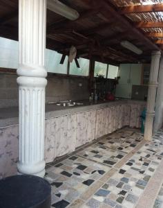une cuisine avec colonnes et comptoir dans un bâtiment dans l'établissement Apartment in Lopar with Balcony, Air condition, WIFI (4224-2), à Lopar