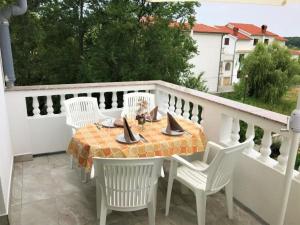 a patio with a table and chairs on a balcony at Apartment in Lopar with sea view, balcony, air conditioning, Wi-Fi (4607-5) in Lopar