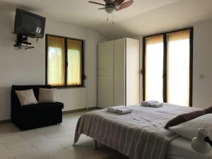 a bedroom with a bed and a tv and a couch at Apartment in Lopar with sea view, balcony, air conditioning, Wi-Fi (4607-5) in Lopar