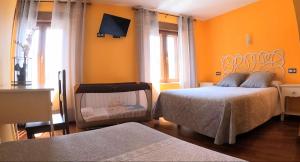 a bedroom with two beds and a tv on the wall at Hostal Plaza Mayor in Carrión de los Condes