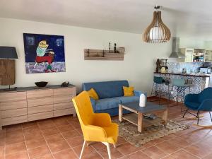 a living room with a blue couch and a table at Cauris Lodge du Marisol vue mer accès direct plage in Le Gosier