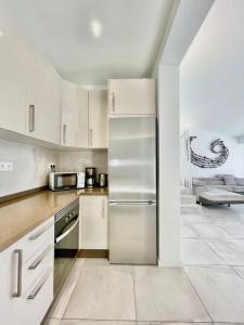 a kitchen with white cabinets and a stainless steel refrigerator at Villa 12 in Adeje