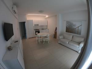 a living room and kitchen with a table and a couch at Orchidea Beach in Civitanova Marche