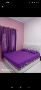 - un lit violet dans une chambre avec un rideau violet dans l'établissement Homestay safari pulau tidung, à Kepulauan Seribu