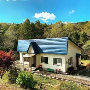 una casa con un techo azul encima en Vacation House ROMAN, en Noboribetsu