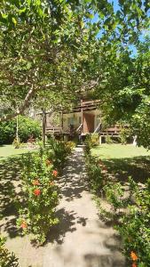 a garden with a pathway leading to a house at Charme do Dido in Ilha de Boipeba