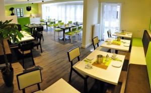 uma sala de jantar com mesas e cadeiras num restaurante em Amiga em Munique