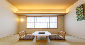 a room with a table and two chairs and a window at Kyoto Hot Spring Hatoya Zuihokaku Hotel in Kyoto