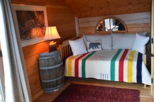 a bedroom with a bed in a log cabin at Seven Sisters Mountains House in Kitwanga