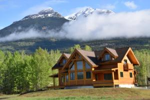 a log home with mountains in the background at Seven Sisters Mountains House in Kitwanga