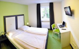 1 dormitorio con 1 cama y escritorio con ordenador portátil en Amiga, en Múnich
