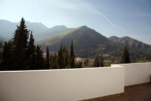 a white fence with a view of a mountain at Alojamientos Madrigal in Cazorla