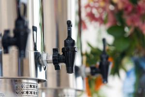 a close up of a water faucet next to a cup at Hotel Mainè in Finale Ligure