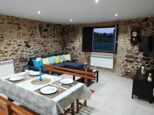 a living room with a table and a couch at BUELIÑA DA CARBALLEIRA in Teo