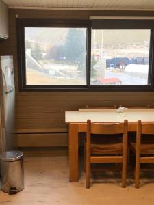 una mesa y una silla en una habitación con ventana en LAS LEÑAS - ATENAS - 5 Personas en Las Lenas