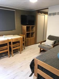 Habitación con mesa y TV de pantalla plana. en LAS LEÑAS - ATENAS - 5 Personas en Las Lenas