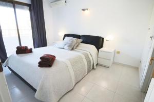 una camera da letto con un grande letto bianco con asciugamani di Pueblo Christina a Fuengirola