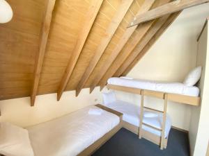 two bunk beds in a room with wooden ceilings at Jagungal in Dinner Plain