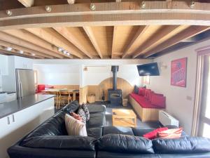 a living room with a black leather couch and a table at Jagungal in Dinner Plain