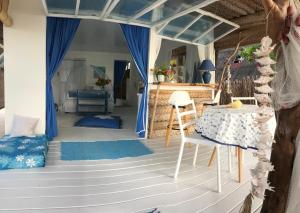 Habitación con mesa y cortina azul en Chez christiane en Tikehau