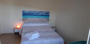 1 dormitorio con 1 cama y una foto del océano en Piso La Buganvilla en Bailén