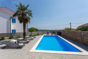 a swimming pool with lounge chairs and a villa at Villa Mia in Garica