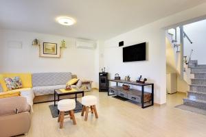 Holiday Home Sandi في بولا: غرفة معيشة مع أريكة وتلفزيون