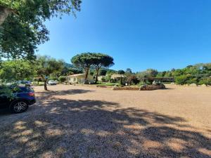 維琪奧港的住宿－Les Jardins De Santa Giulia - Charmante chambre d'hôte，停在一个有树的停车场的汽车