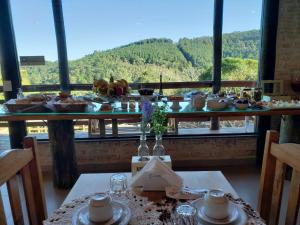 uma mesa com um buffet de comida numa sala em Pousada Cabana na Floresta - Monte Verde em Camanducaia