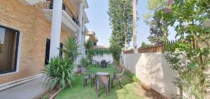 a patio with chairs and tables in a yard at Infinity Villa in Islamabad +14 photos