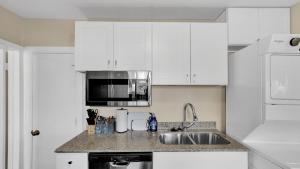 a white kitchen with a sink and a microwave at Escape to Serenity in Colorado Springs +5 photos