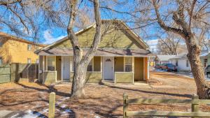 una casa gialla con un albero e una recinzione di Escape to Serenity a Colorado Springs