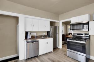 a kitchen with white cabinets and stainless steel appliances at Finding Tranquility in Colorado Springs