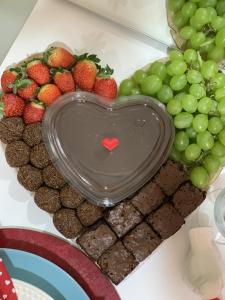a heart shaped plate of chocolate and fruit on a table at Suite Starfish in Guarujá