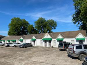 a building with cars parked in a parking lot at ASAM HOTEL in Vicksburg