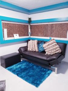 a living room with a brown couch and a blue wall at M/H House in Carolina